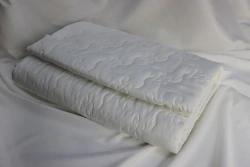 Quilted coverlets of cotton and synthetic fabrics, filled with cotton and synthetic fibres.
