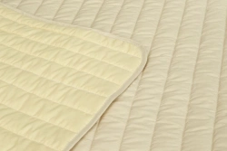 Quilted coverlets of natural fabrics with synthetic and mixed fillings