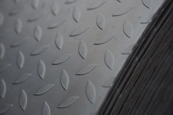 Hot-rolled unalloyed flat steel in coils, 600 mm wide and over, with relief pattern (fluted coil)
