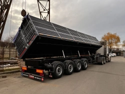 Side-loading tipper semi-trailer type 85337, modification 853373. Metal tipper body of square cross-section with an o